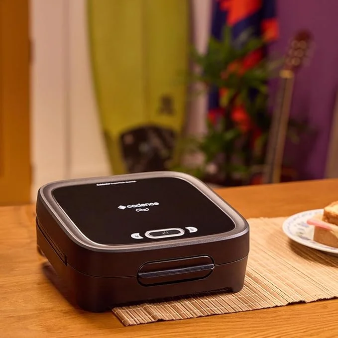 Imagem de uma sanduicheira elétrica cadence click em cima de uma mesa de madeira