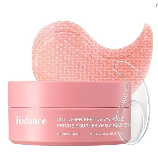 A pink jar of Biodance Collagen Peptide Eye Patches for the under-eye area. Behind the jar, two pink hydrogel patches with a honeycomb texture are visible, along with a small transparent applicator spatula. The label text is clear in both English and French.